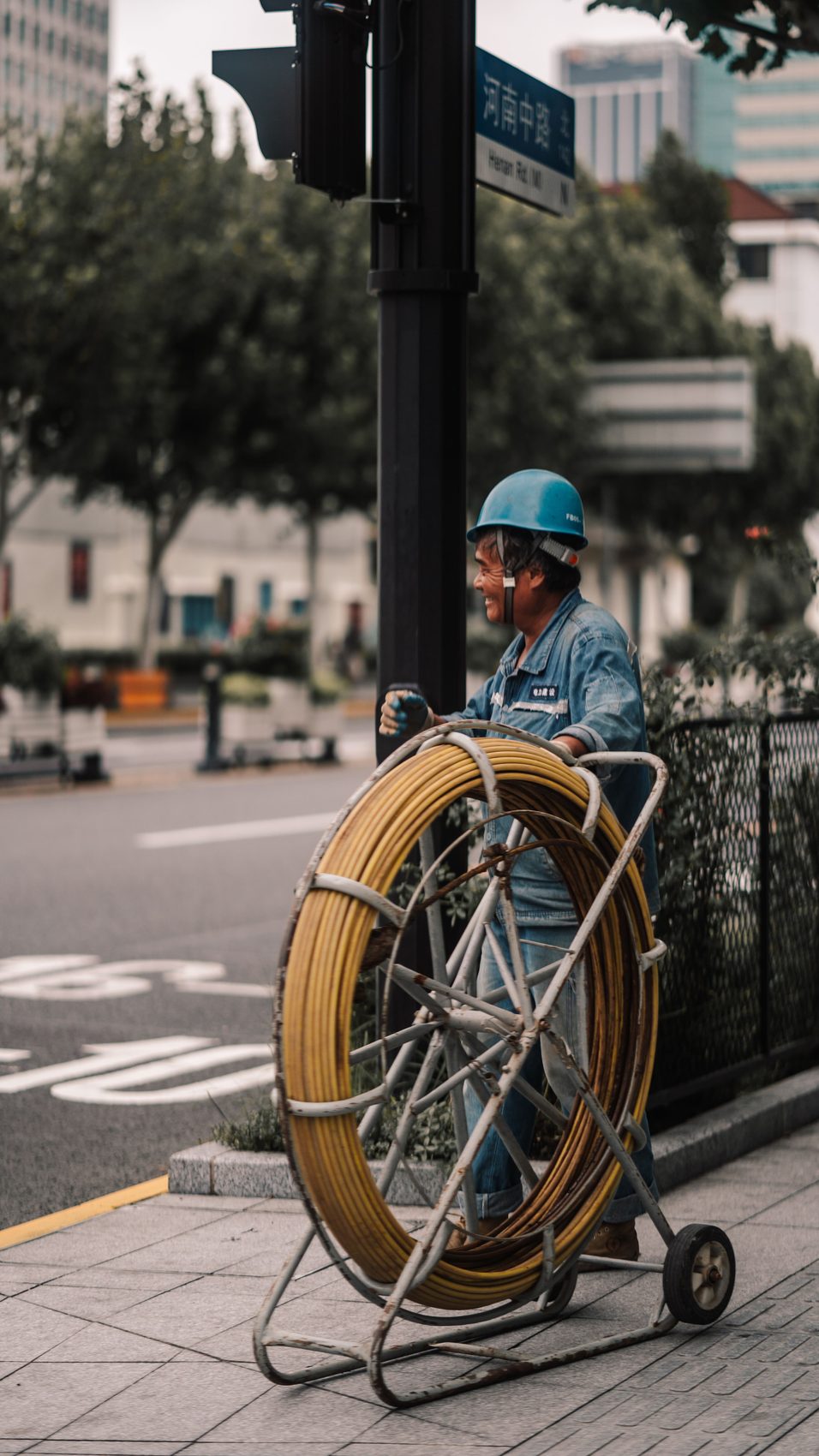 Plumber unspooling a drain cleaning cable reel on site