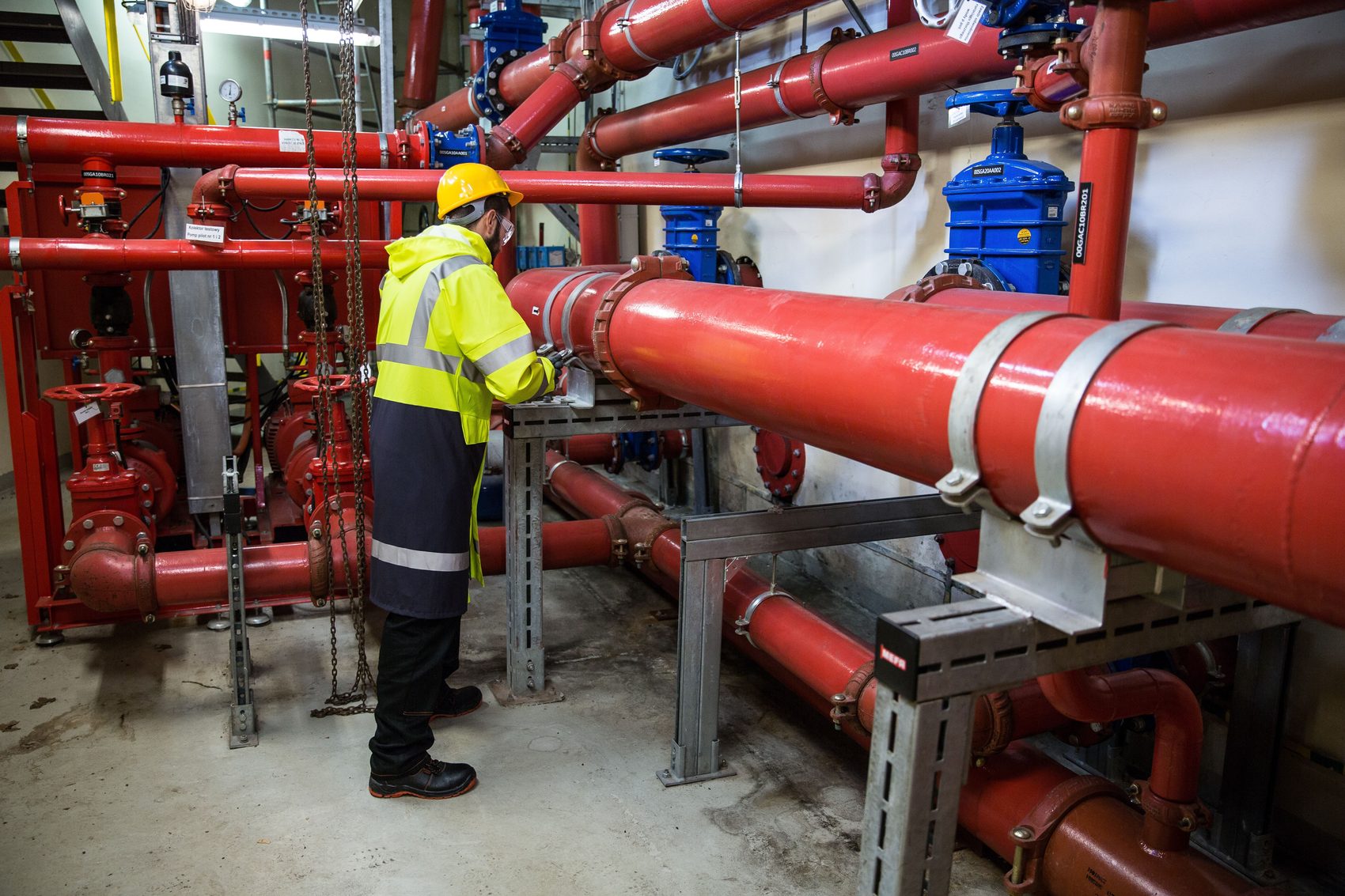 Technician inspecting a large industrial pipe system